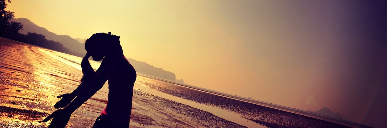 How Exposure Response Prevention Therapy Helped Me Manage My OCD woman at the beach with her arms out watching the sunrise