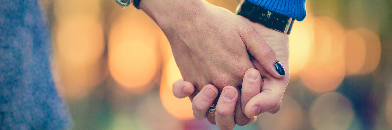 How We've Made Our Marriage Work as Special Needs Parents Couple holding hands outdoors.