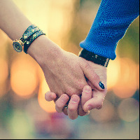 Couple holding hands outdoors.