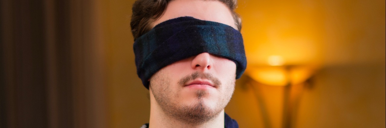 Response to Foundation Fighting Blindness #HowEyeSeeIt Campaign Blindfolded young man at home in living room