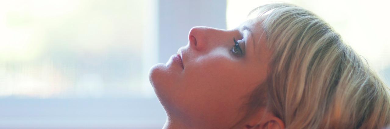 woman sitting on couch looking at the ceiling