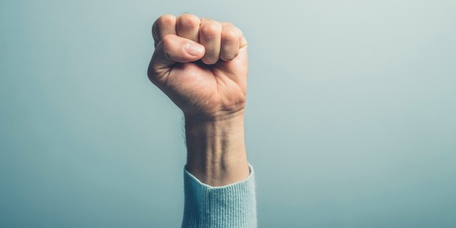 man holding first in the air