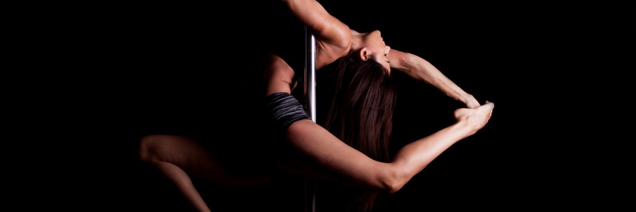 pole dancer in dark setting