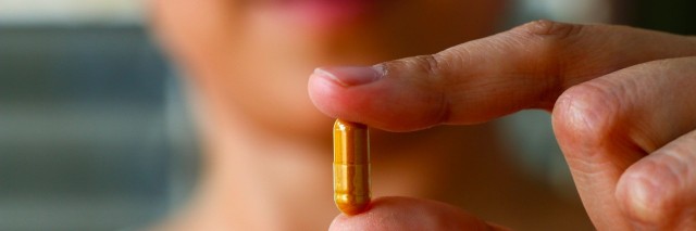 a woman holding a pill