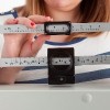 Close-up view of a woman adjusting a medical weight scale