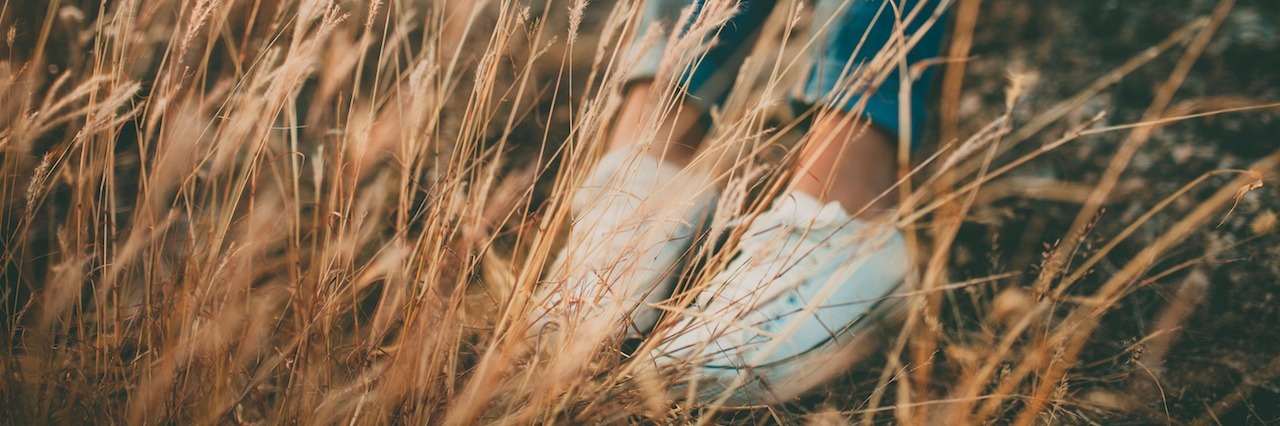 woman sitting in a field of tall grass