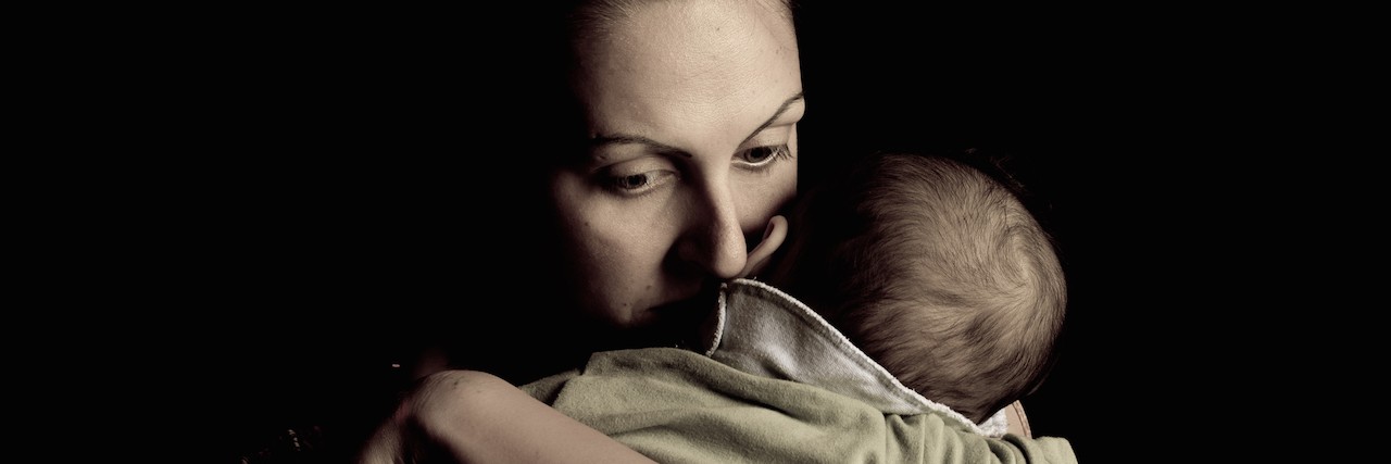 I Want Postpartum Suicide to End – Here Are Some Ways You Can Help mother holding her baby looking sad