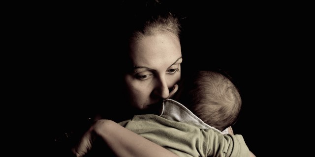 mother holding her baby looking sad