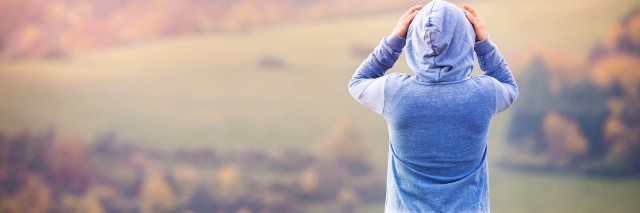 woman wearing a hoodie looking at mountains