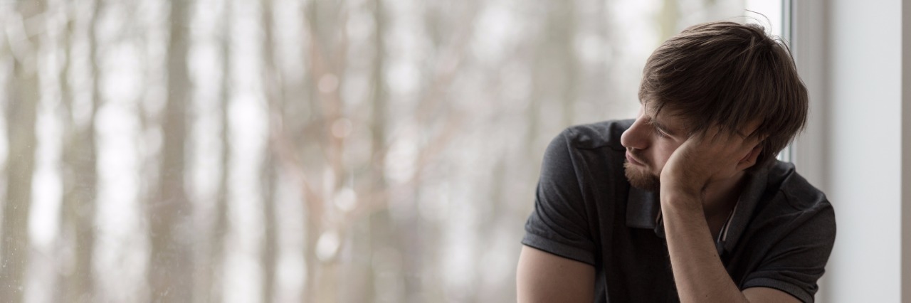 Depression: Needing Care and Assumptions About Capability young miserable depressed man sitting and thinking by window