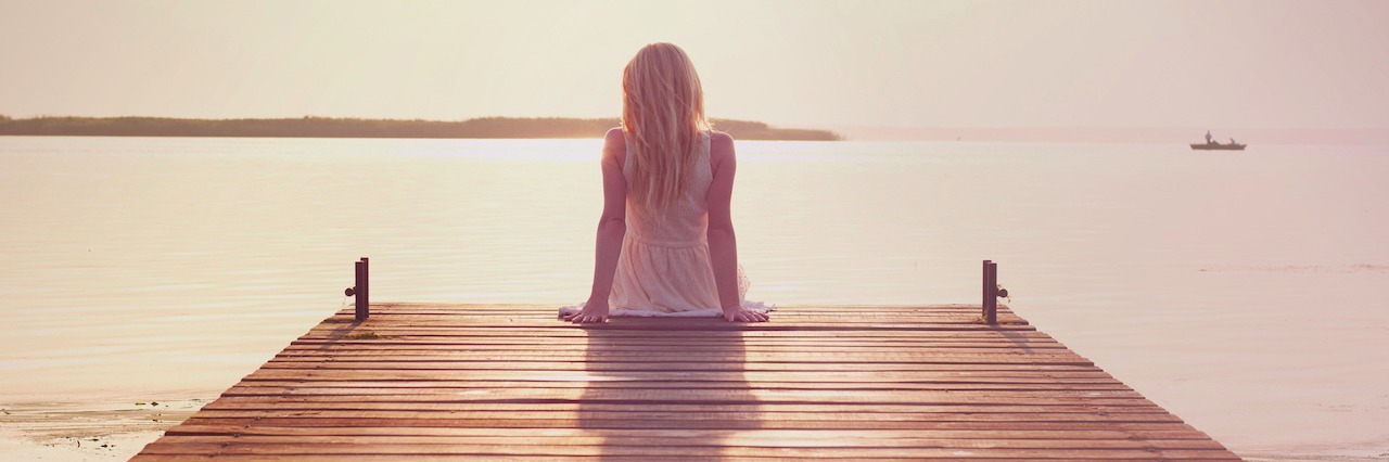 Letter to Graduating Class About My Schizoaffective Disorder woman sitting on a dock