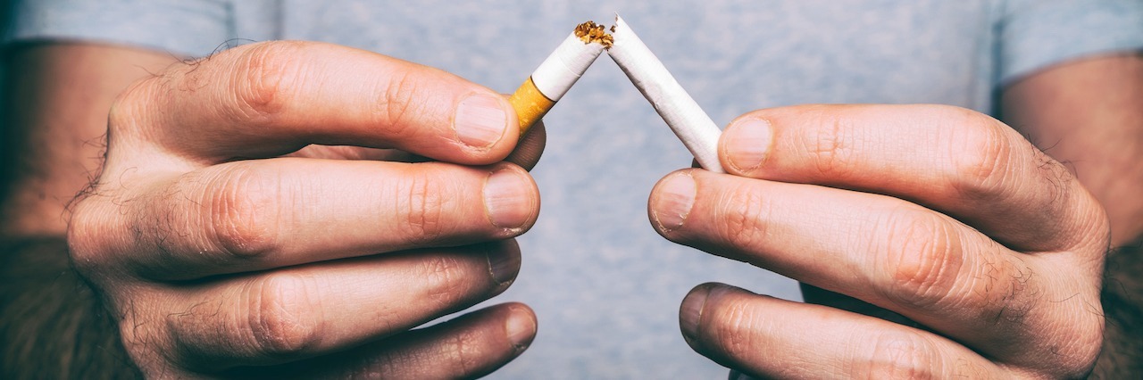 When Addiction Becomes a Tool to Cope With Depression a person breaking a cigarette