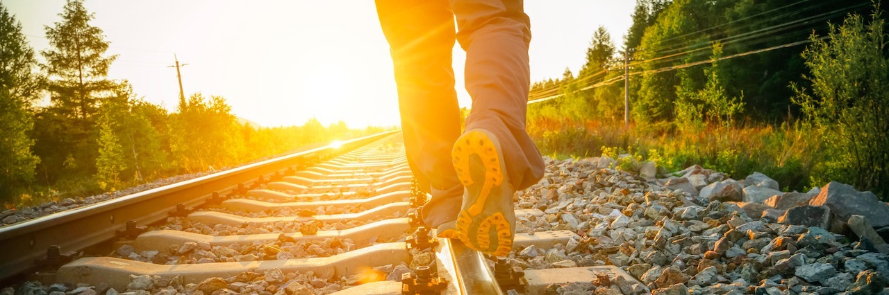 man walking on the train tracks