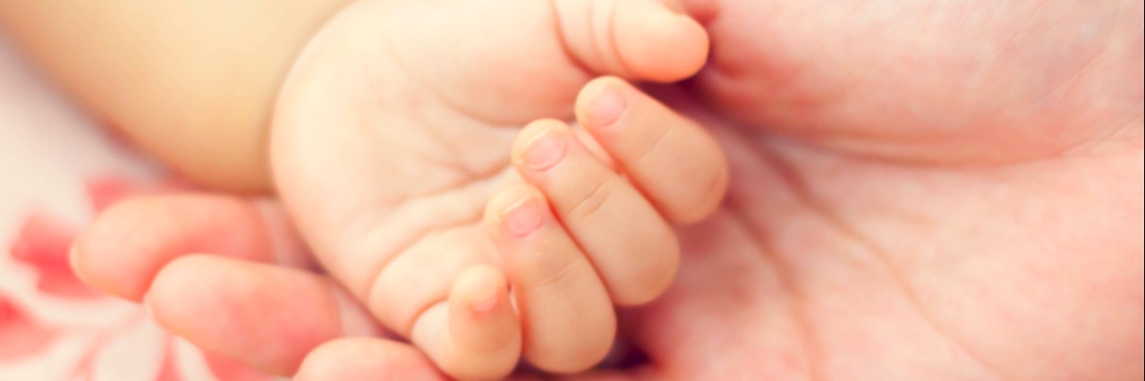 Letter to the Baby Sister of My Son With Special Needs Holding baby's hand in hand