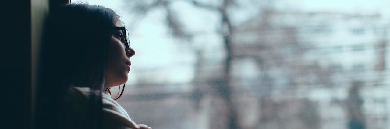Dysthymia: The Self-Doubt That Comes With Depression girl with glasses looking out a window