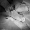 The child's feet in mother's hands in black and white image