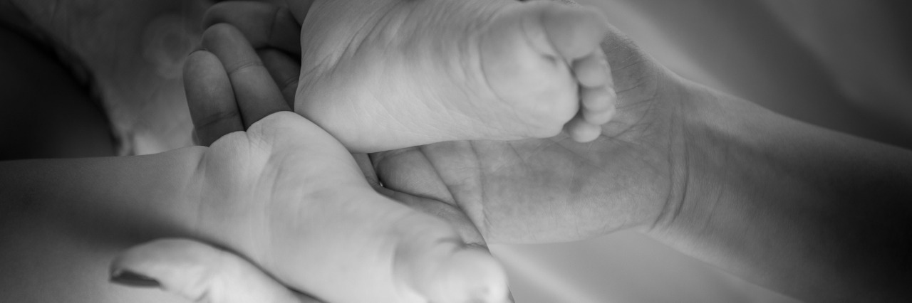 A Letter to the Health Ministers of Northern Ireland About Postnatal Depression The child's feet in mother's hands in black and white image