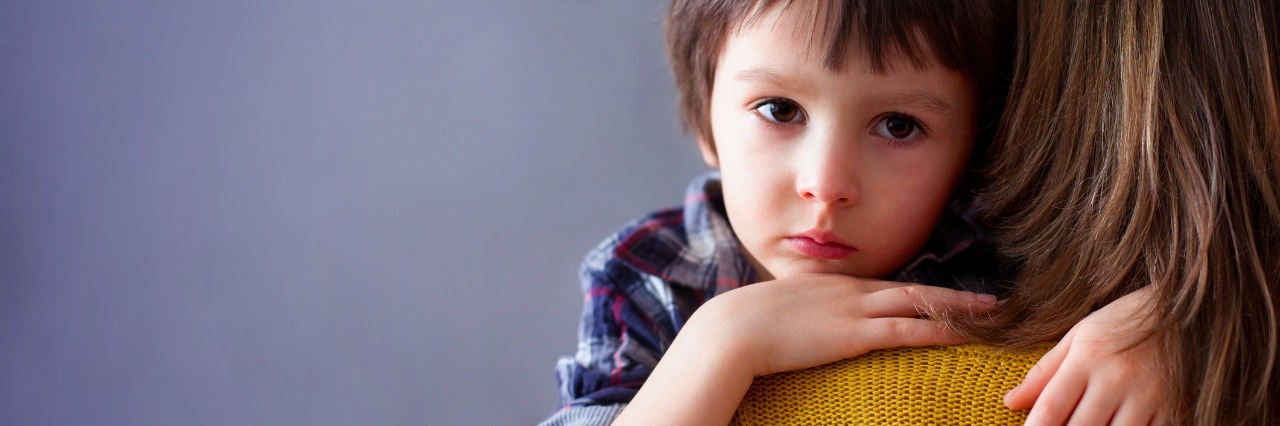 Pursuing Treatment With Drug Companies for Canavan Disease Sad little child, boy, hugging his mother at home, isolated image, copy space. Family concept