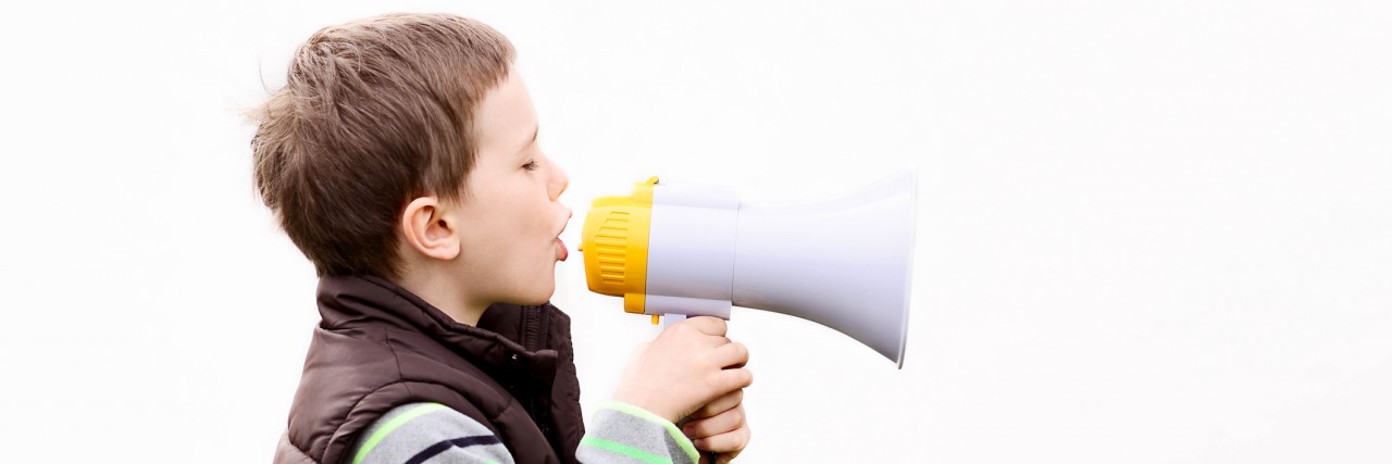Having Autism, Hating Loud Noises and Being the Loudest Kid I Knew Little boy in the brown vest shouts something into the megaphone - white background