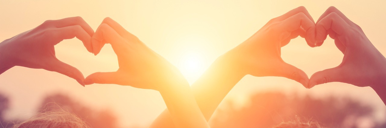 What I Learned From Being Disabled and Having an Able-Bodied Friend two women making heart shapes with hands above heads