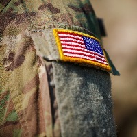 close up of us flag patch on the arm of a soldiers uniform