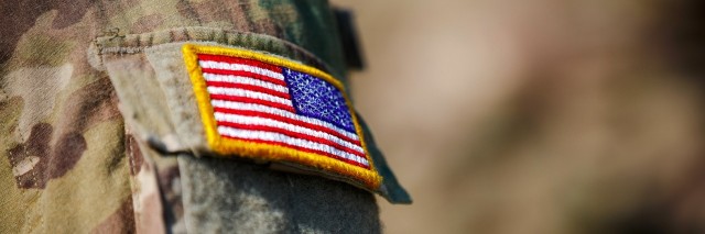 close up of us flag patch on the arm of a soldiers uniform