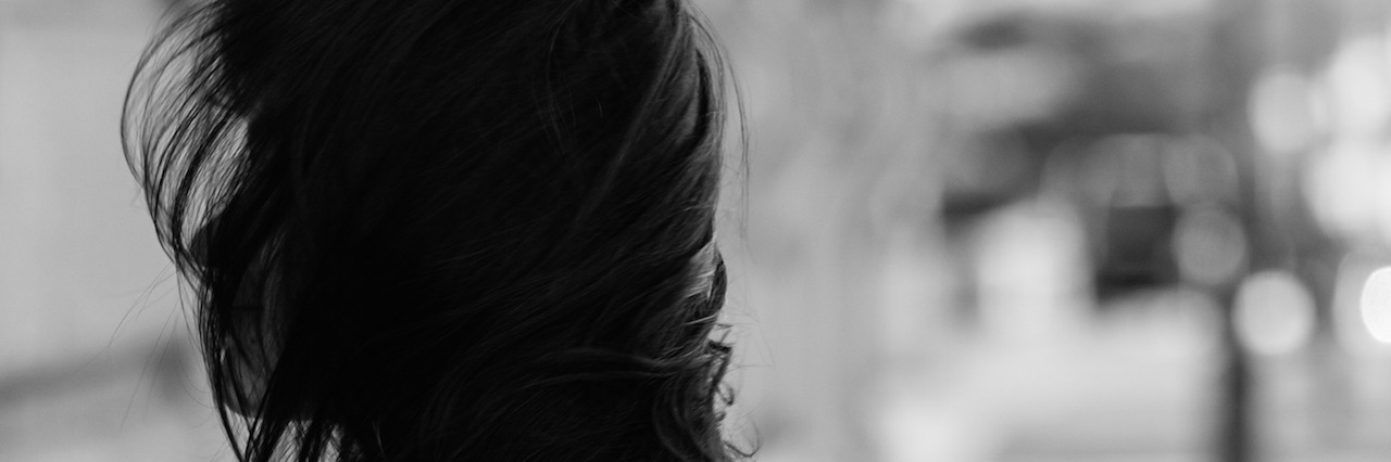 girl with hair blowing in face in black and white