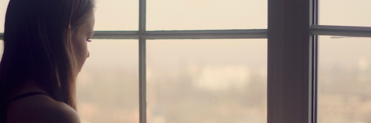Dealing With Pressure to Overcome My Illness and Be Positive woman holding coffee cup looking out window in the morning