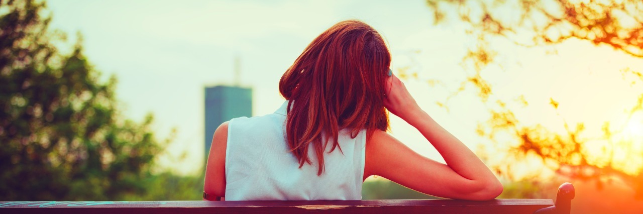 Depression: How to Help Us woman sitting on a park bench