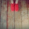 women legs wearing red shoes walking on wooden floor