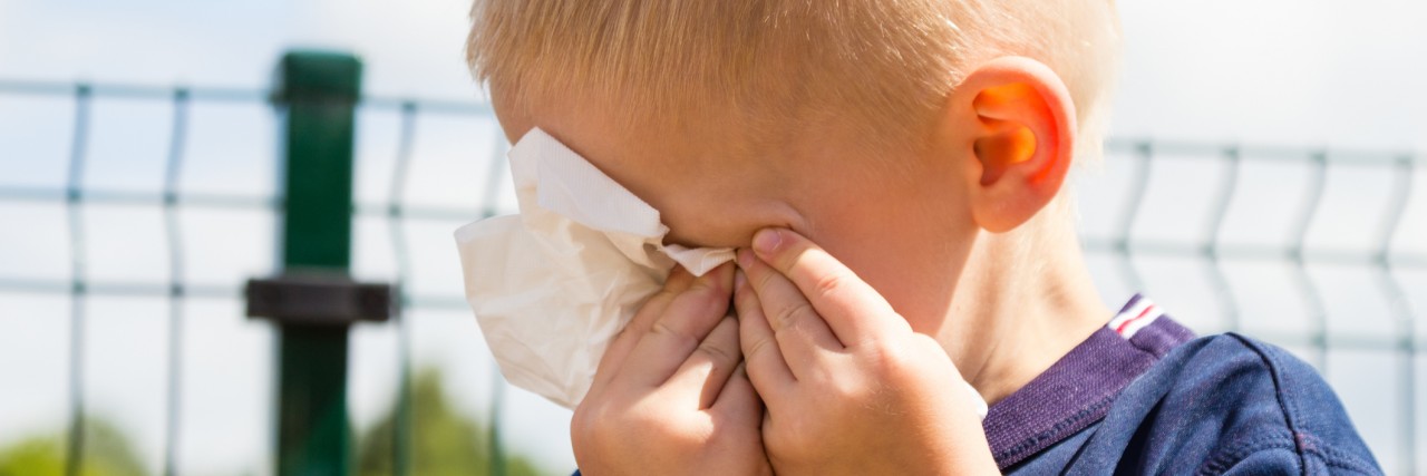 My Autistic Child Acts Differently at Home Than at School Emotions and feeling. Sad little boy crying, unhappy child wiping his eyes with tissue outdoor