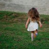 photo of little beautiful running girl outside