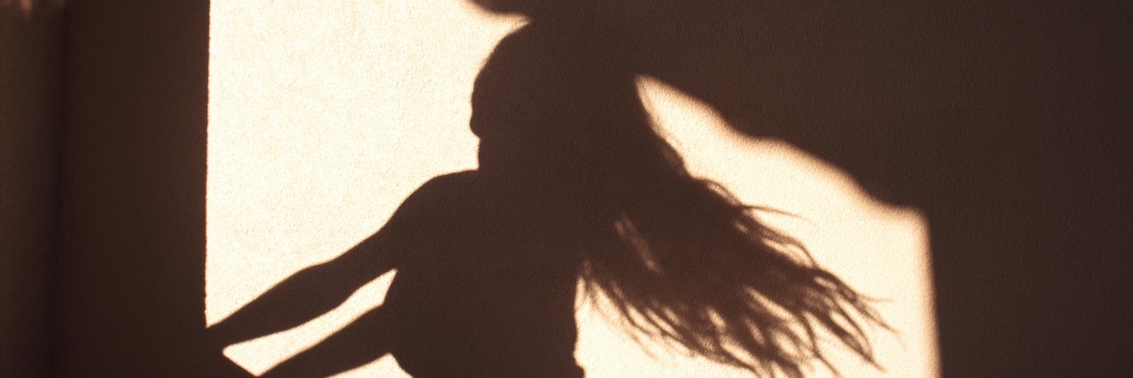 silhouette of a woman with her hair flying behind her