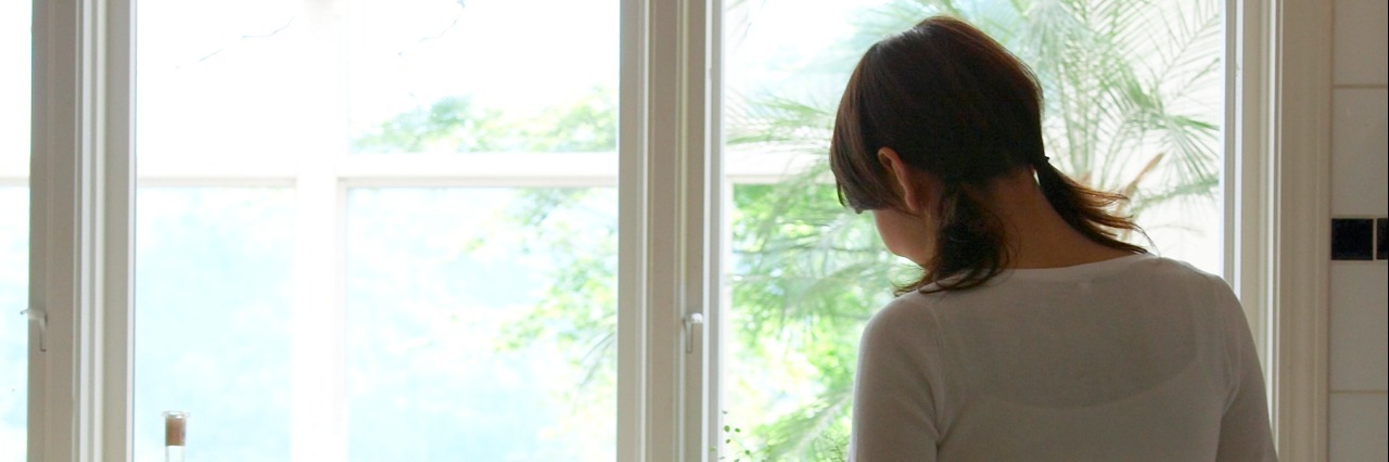 What My Days Are Like With Chronic Lyme Disease and Chronic Pain Woman standing at kitchen sink, rear view