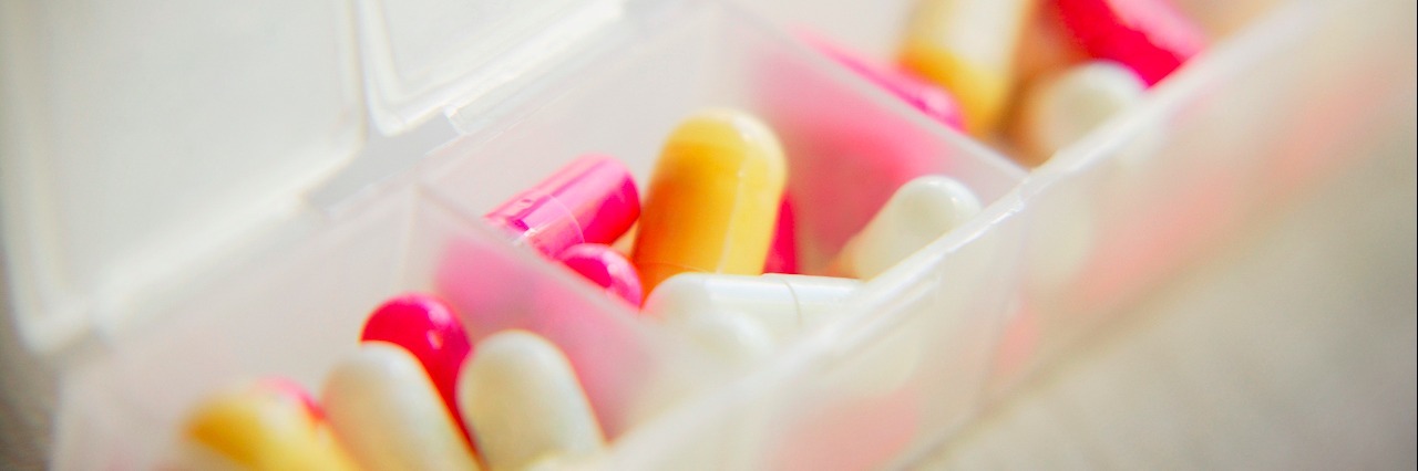pink and yellow pills in pill organizer