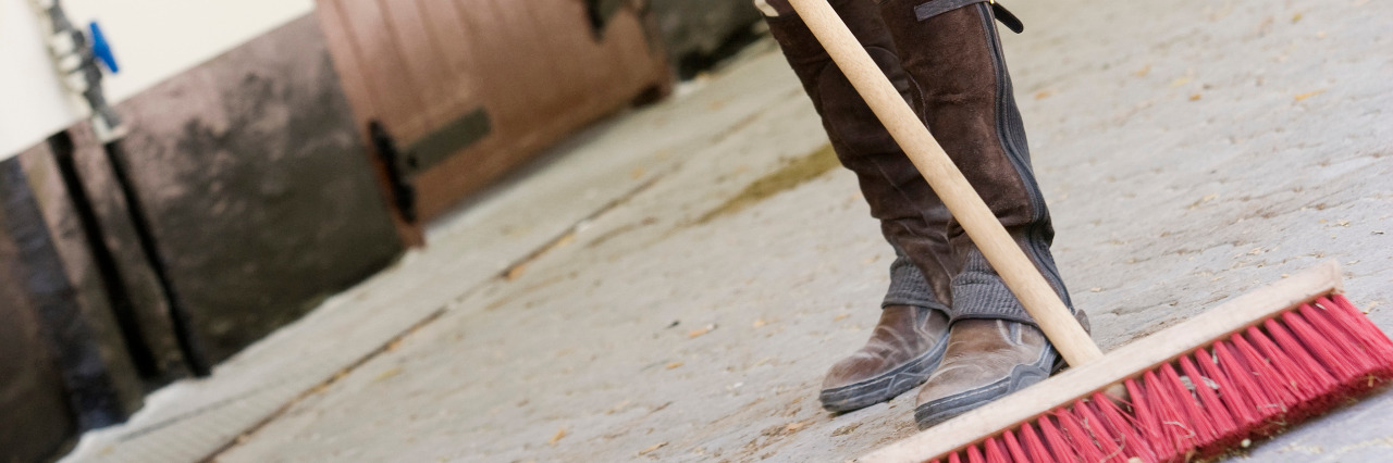 How Childhood Jobs Prepared Me for Success as an Autistic Adult Woman sweeping stable.