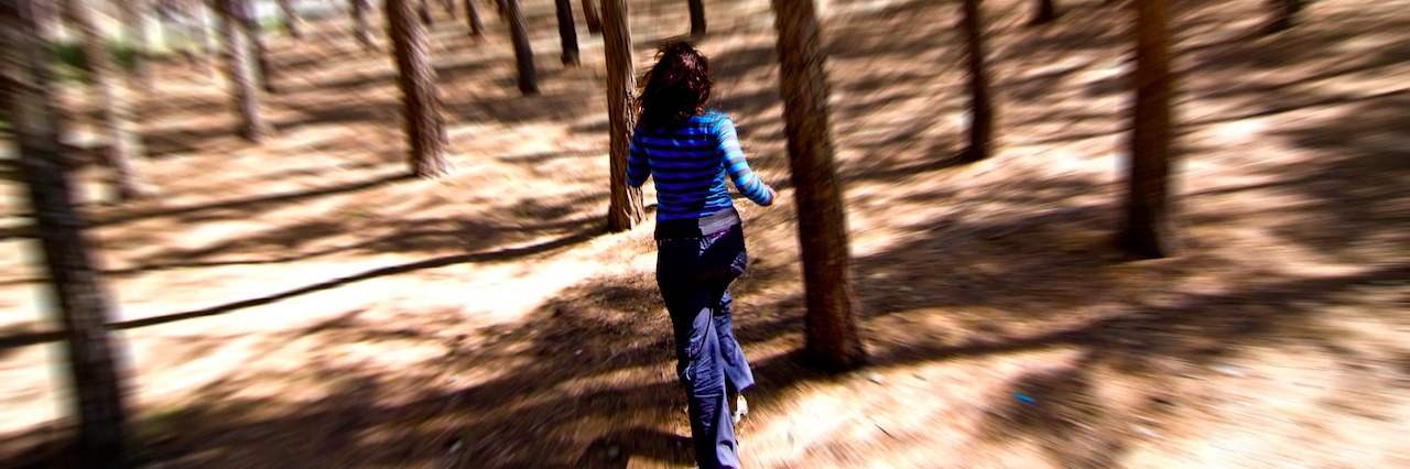 a woman running through the woods