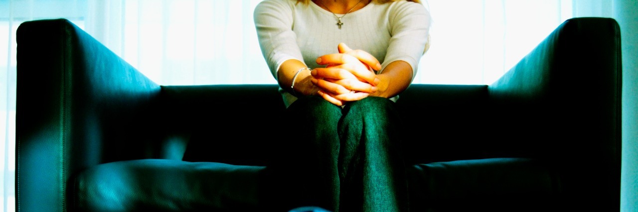 The Anxiety of Getting Help woman sitting on couch with hands folded