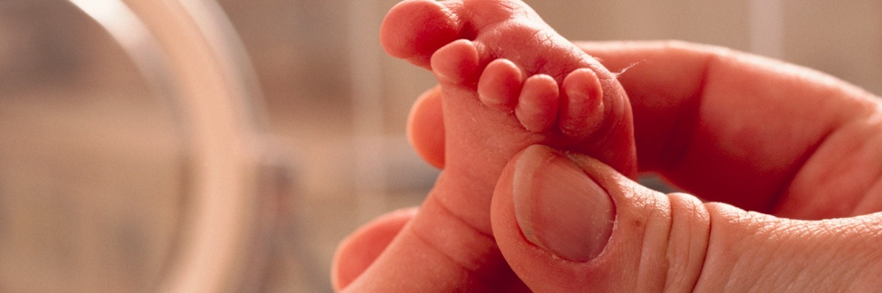 A Letter to a New Mom With a Baby in the NICU Hand holding a baby's foot in the hospital