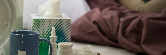 Tissue, flu medicines and tea on bedside table sick woman