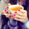 Girl wrapped in a blanket holding a cup of tea close-up