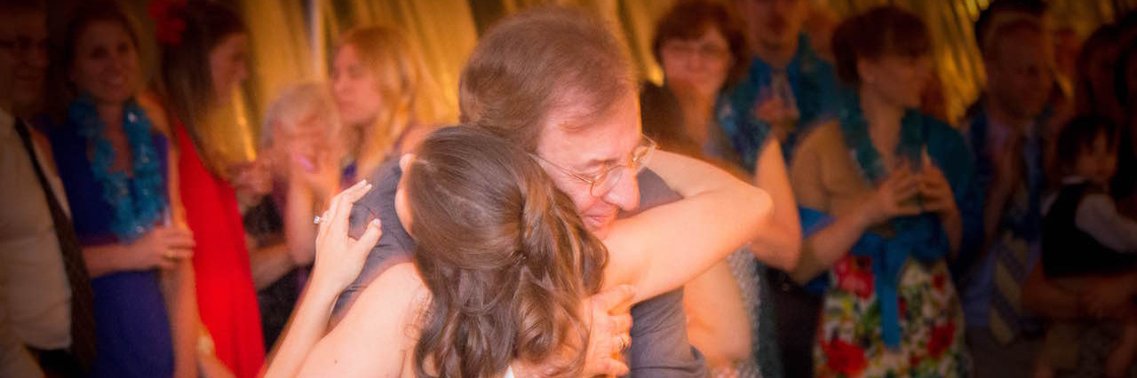 A woman and her father embrace at her wedding
