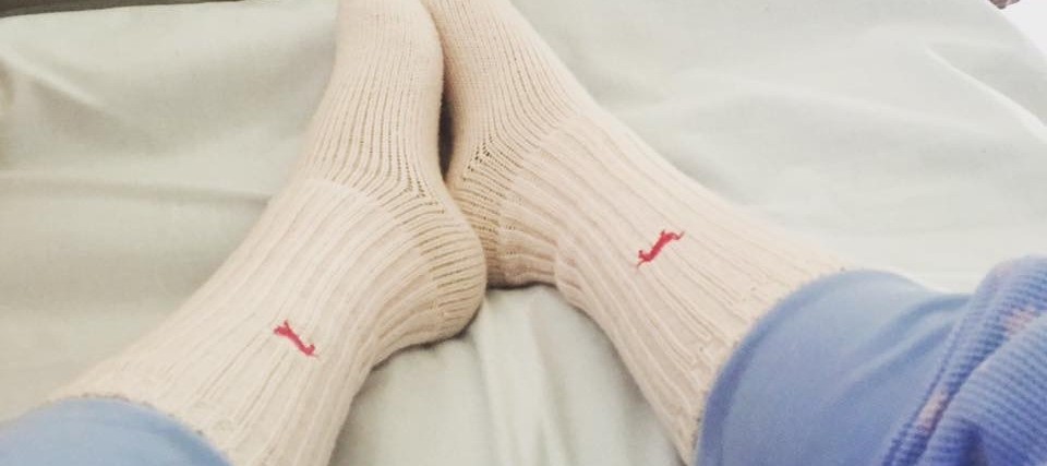 legs and feet wearing socks in hospital bed