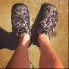 feet wearing hiking shoes standing on wet ground