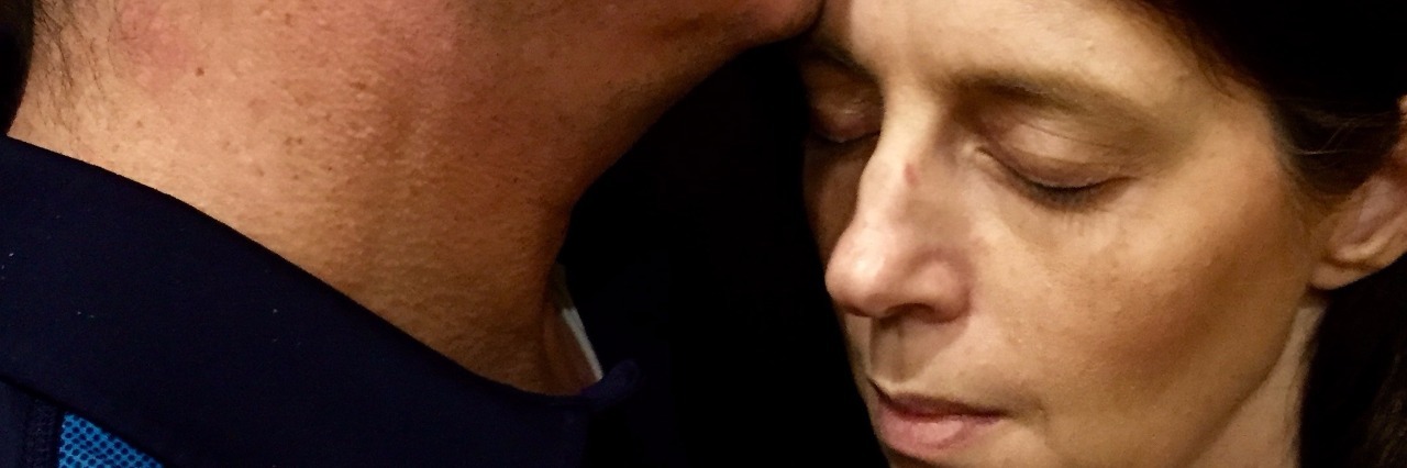 Advice for Caregivers of a Sick Spouse husband kissing wife on forehead