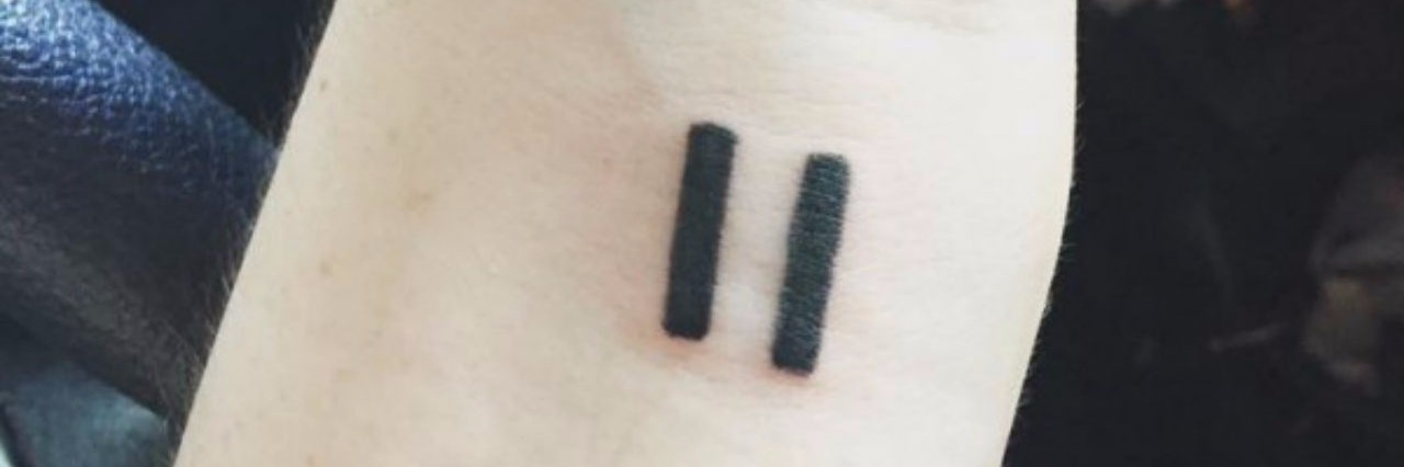 What People Don't Say About Practicing Mindfulness With Anxiety a tattoo of a pause sign on a persons wrist