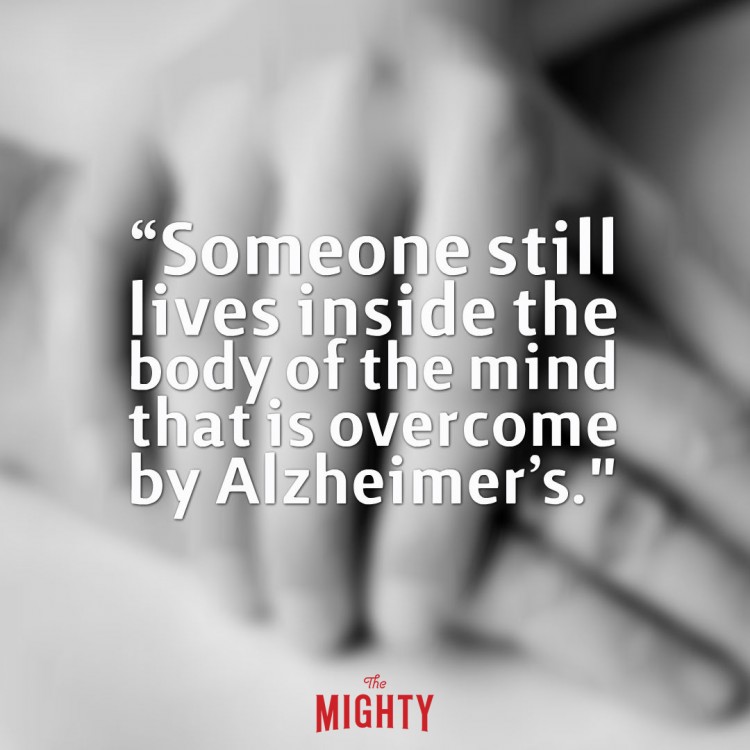 blurry hands holding with text that says someone still lives inside the body of the mind that is overcome by alzheimers