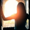 Silhoutte of woman opening window