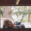 boy resting head on arm in windowsill