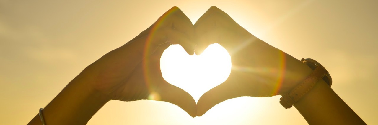 Anorexia Recovery: Learning to Love Yourself hands in the shape of a heart in front of the setting sun